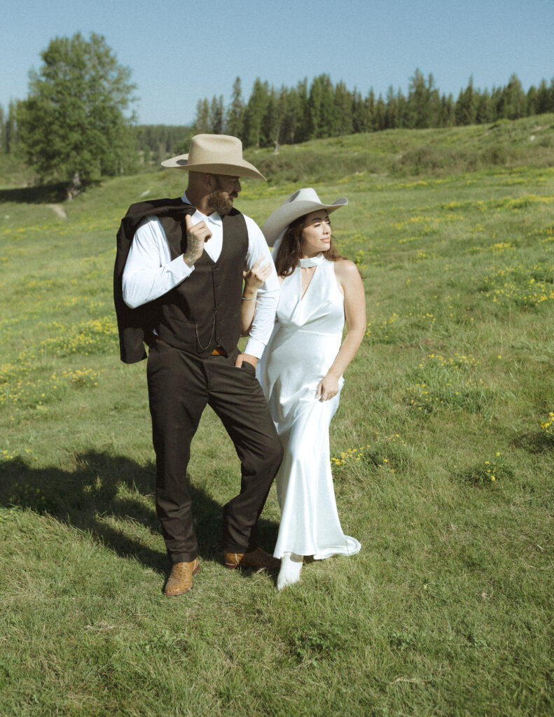 couple taking photos with horses after their lake McDonald elopement