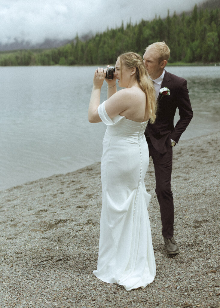 bride and groom taking photos after their lake McDonald Lodge Elopement