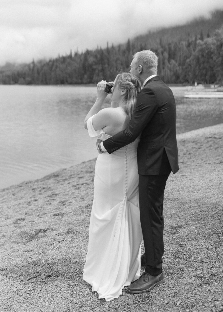 bride and groom taking photos after their lake McDonald Lodge Elopement