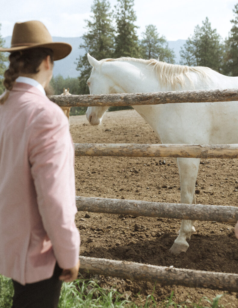 couple taking photos with the horses for their logan pass elopement