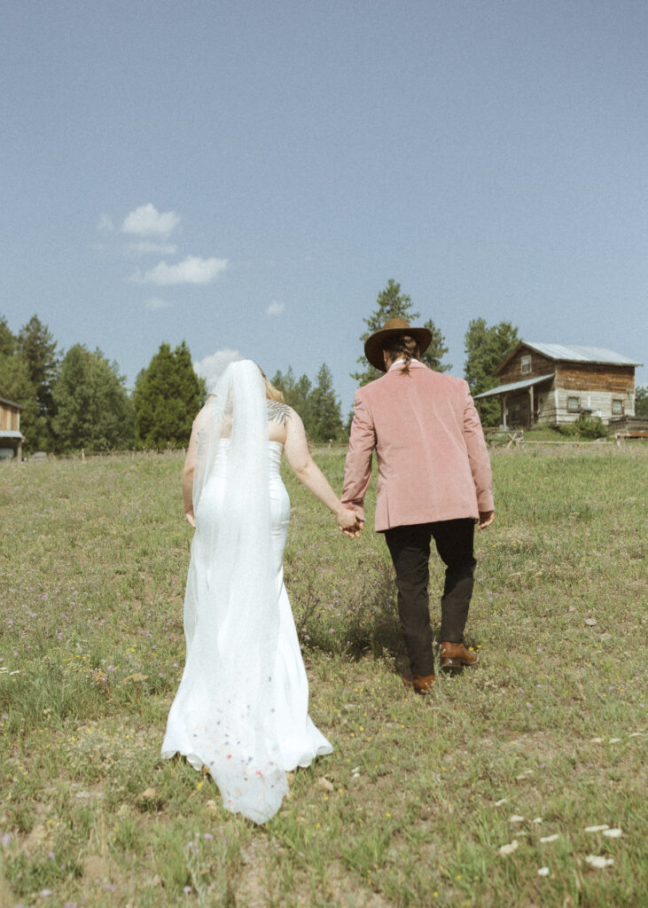 couple taking photos with the horses for their logan pass elopement