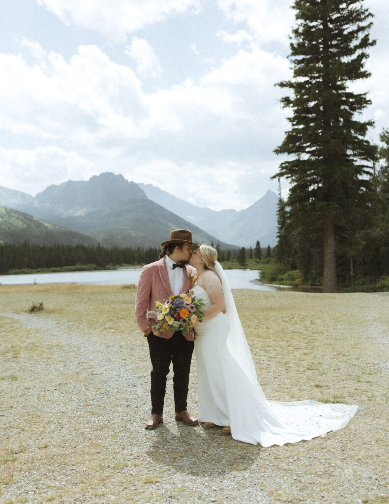 couple taking photos at a lake before their logan pass elopement
