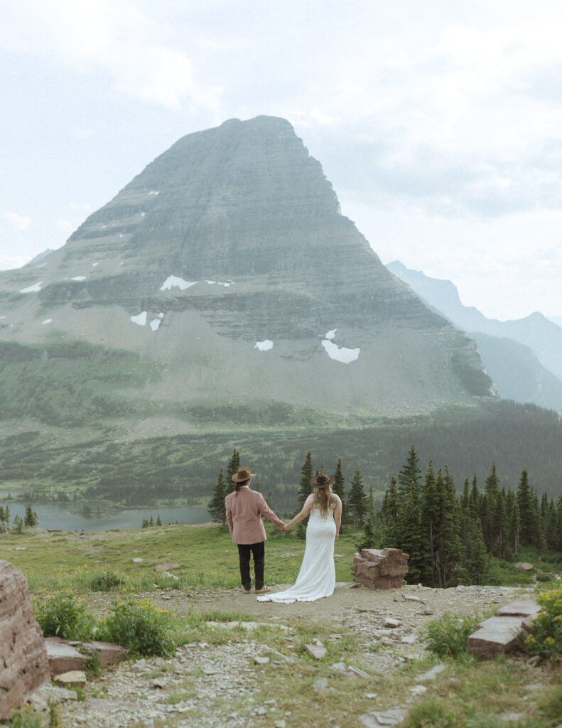 couple taking their wedding photos for their logan pass elopement