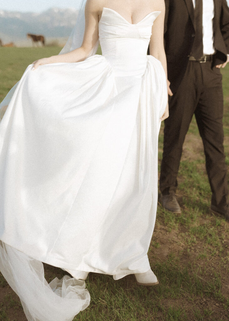 couple taking photos with horses for their Wyoming horse elopement