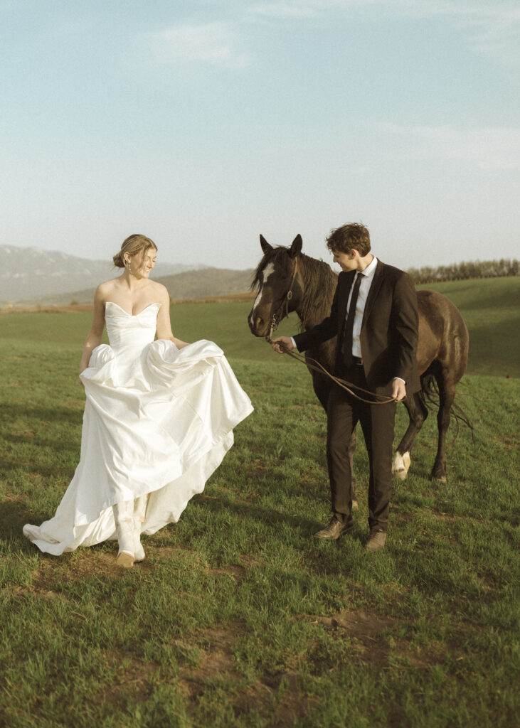 couple taking photos with horses for their Wyoming horse elopement