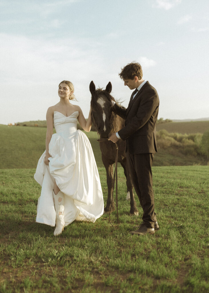 couple taking photos with horses for their Wyoming horse elopement