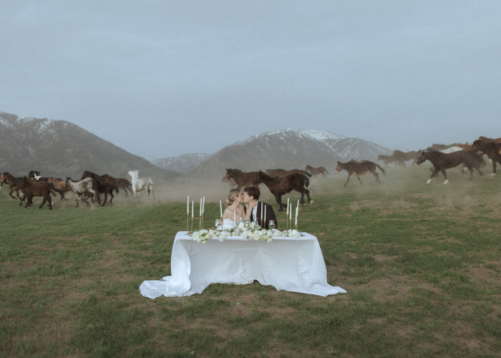 horses running behind couple at their Wyoming horse elopement
