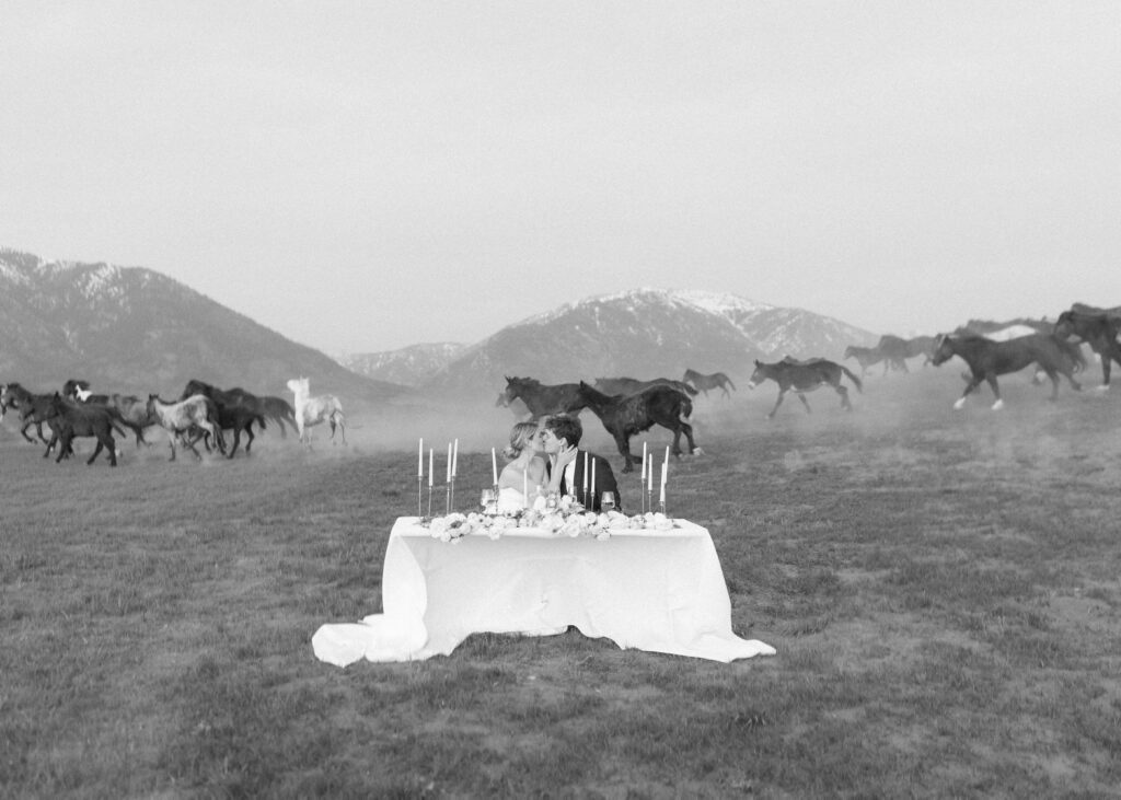 horses running behind the couple at their Wyoming Horse Elopement